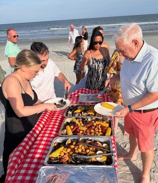 Guests serving themselves at a Lowcountry seafood boil on the beach